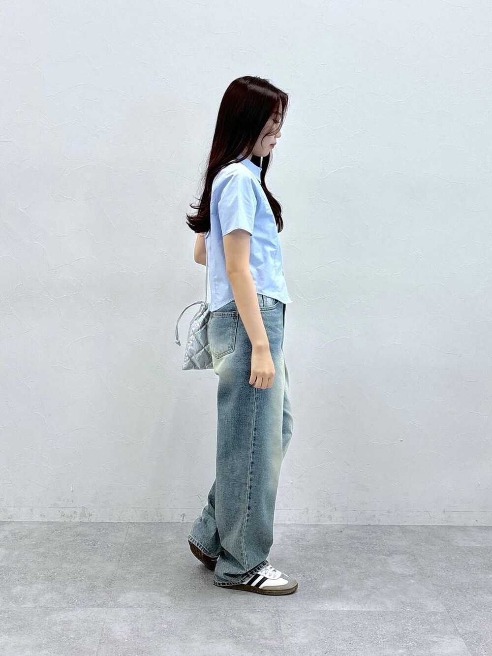 ブルー系のデニムパンツ、シルバー系のショルダーバッグ、ブルー系のシャツ/ブラウスを着用したレディースの夏コーディネートの4枚目の写真