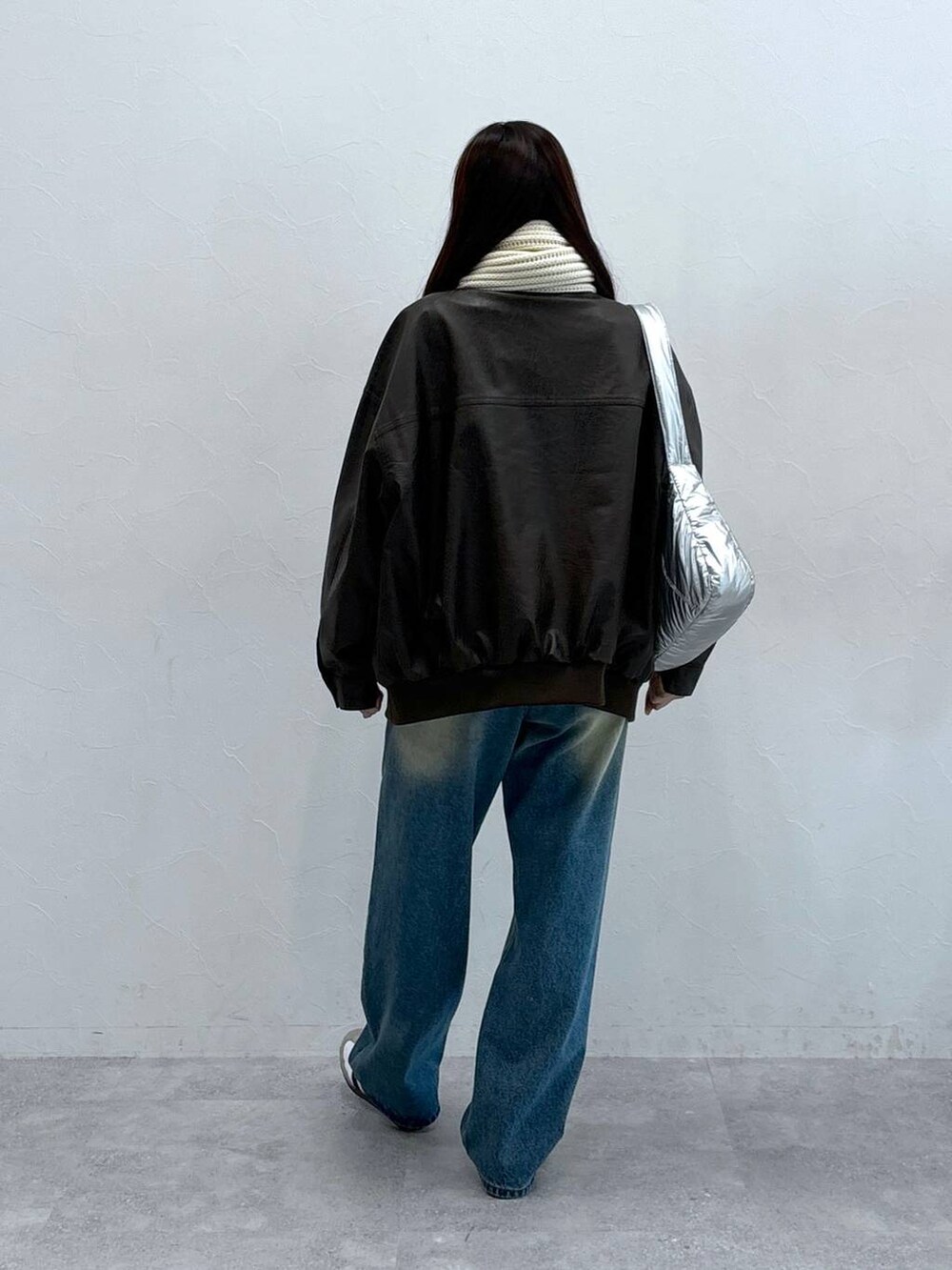 その他のショルダーバッグ、ブラウン系のライダースジャケット、ブルー系のデニムパンツを着用したレディースの秋コーディネートの4枚目の写真