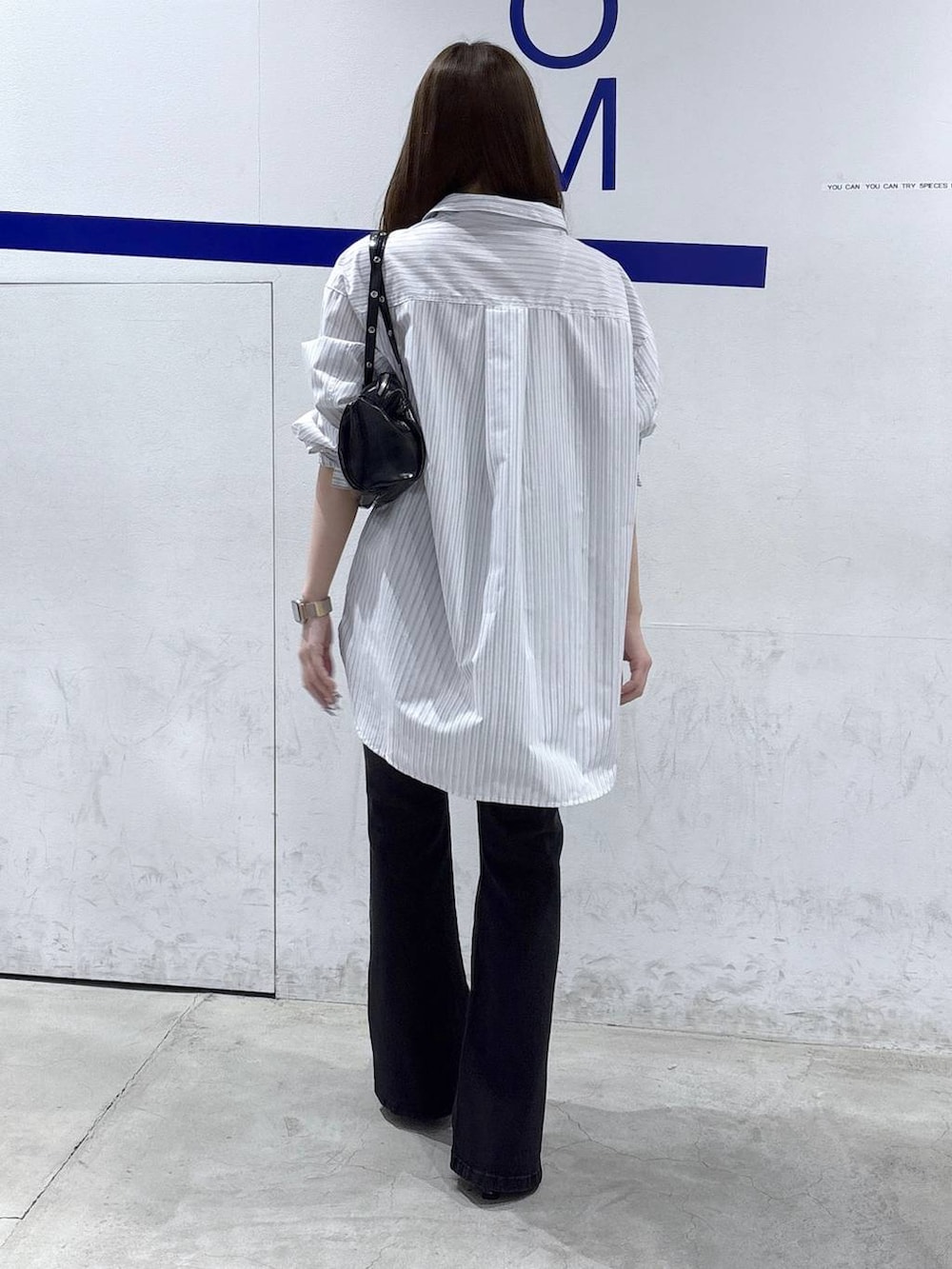 ブラック系のデニムパンツ、ホワイト系のパンプス、ホワイト系のシャツ/ブラウスを着用したレディースの春コーディネートの4枚目の写真