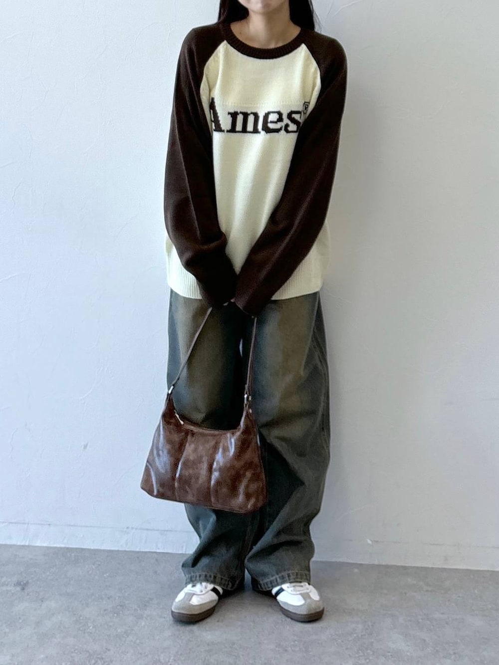 ブラウン系のニット/セーター、ブルー系のデニムパンツ、ブラウン系のハンドバッグを着用したレディースの冬コーディネートの3枚目の写真