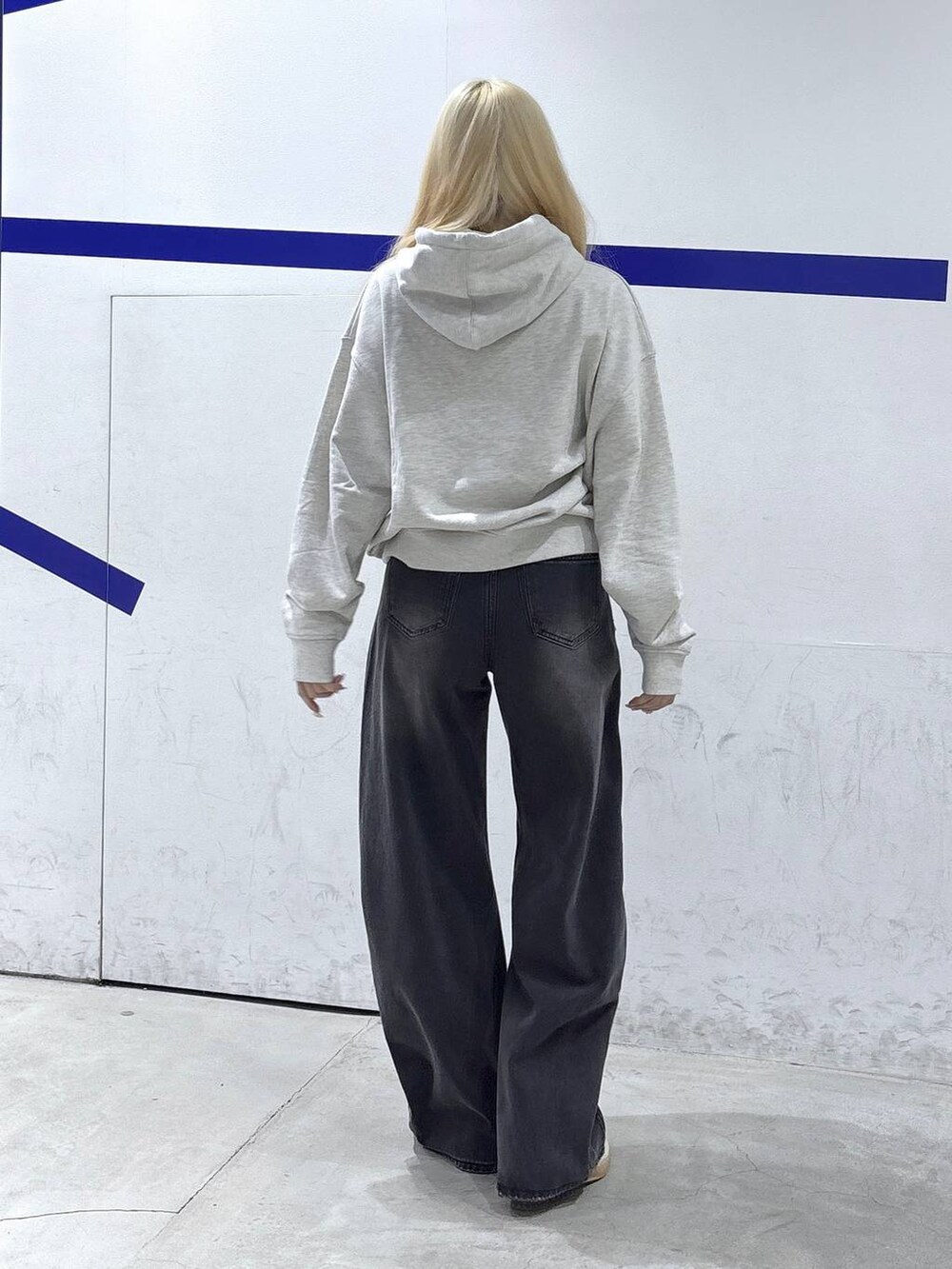 ブラック系のデニムパンツ、ベージュ系のパーカーを着用したレディースの秋コーディネートの3枚目の写真