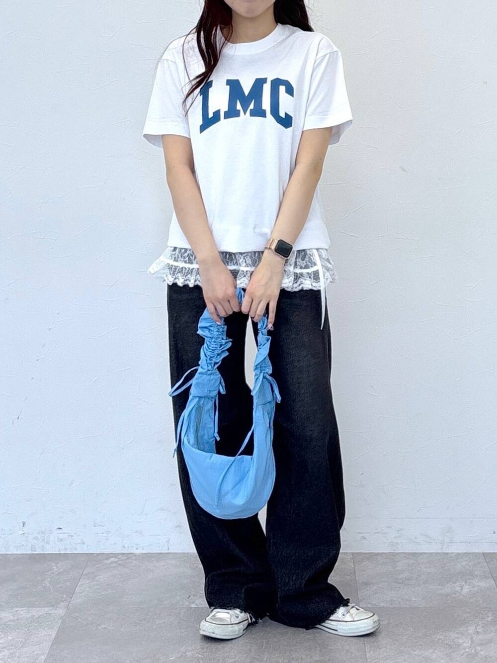 ブルー系のショルダーバッグ、ブラック系のデニムパンツ、ホワイト系のTシャツ/カットソーを着用したレディースの春コーディネートの2枚目の写真