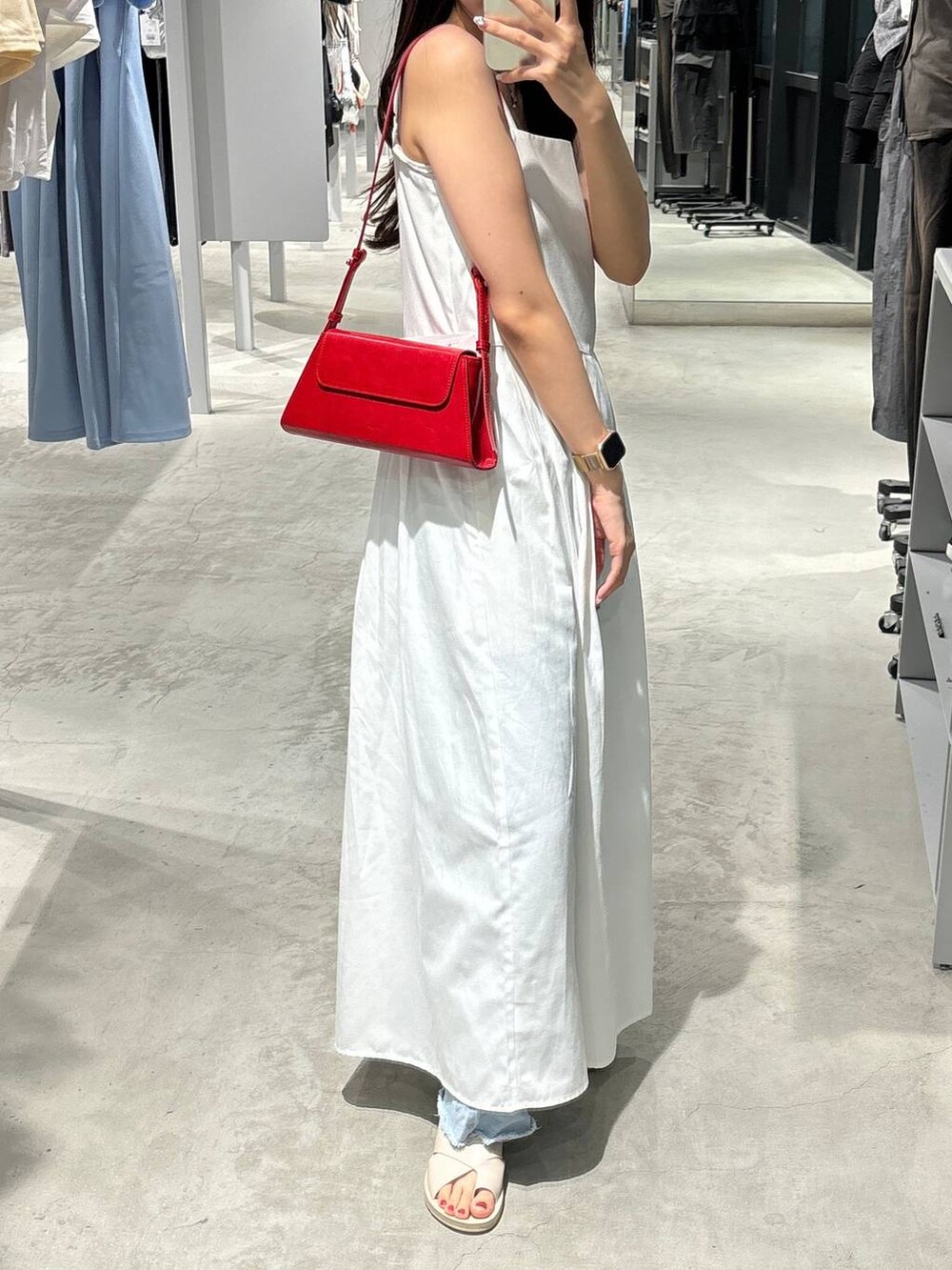 ホワイト系のワンピース、ベージュ系のサンダル、レッド系のショルダーバッグを着用したレディースの夏コーディネートの3枚目の写真