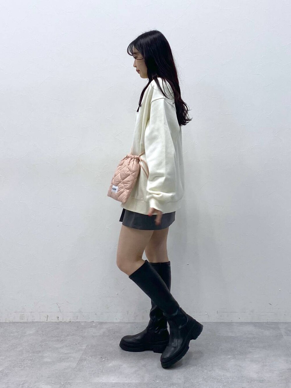 ピンク系のショルダーバッグ、グレー系のスカート、ベージュ系のスウェットを着用したレディースの冬コーディネートの3枚目の写真