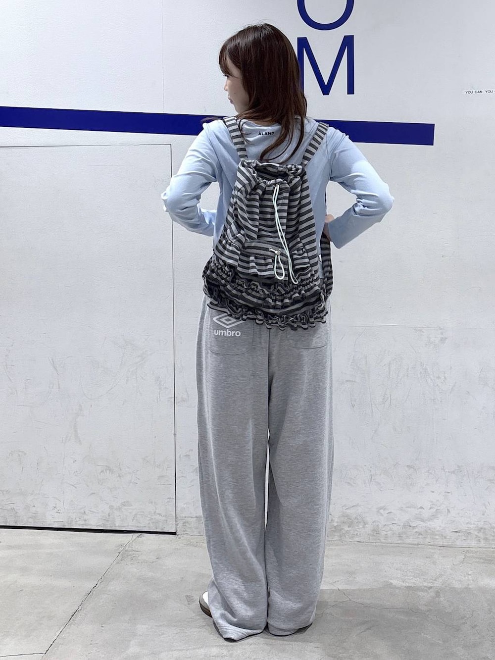 グレー系のスウェットパンツ、ブルー系のTシャツ/カットソー、グレー系のバックパック/リュックを着用したレディースの秋コーディネートの4枚目の写真