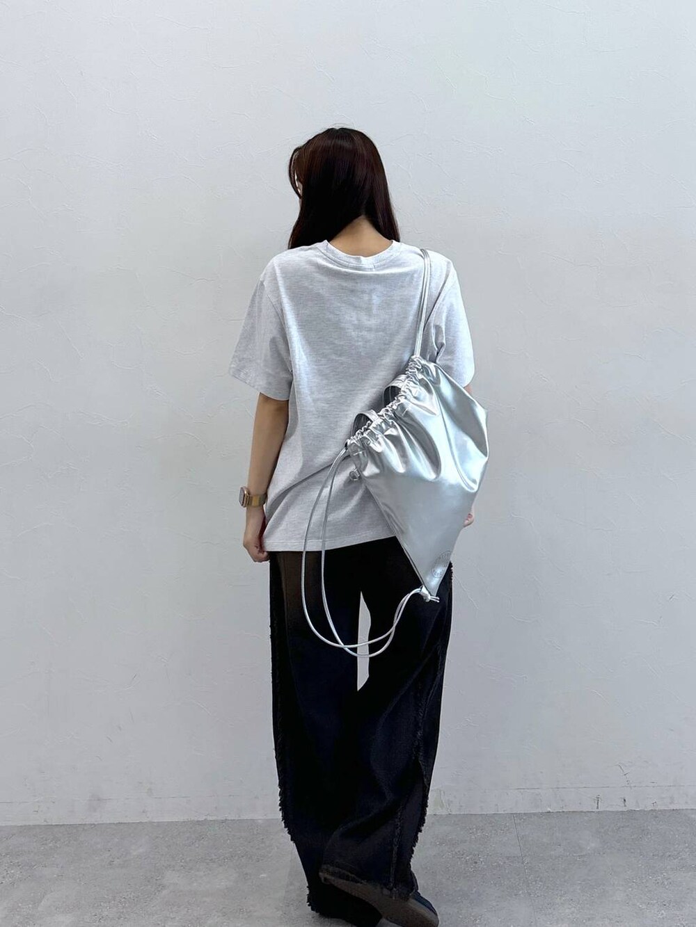 ブラック系のデニムパンツ、グレー系のTシャツ/カットソー、グレー系のバックパック/リュックを着用したレディースの夏コーディネートの4枚目の写真