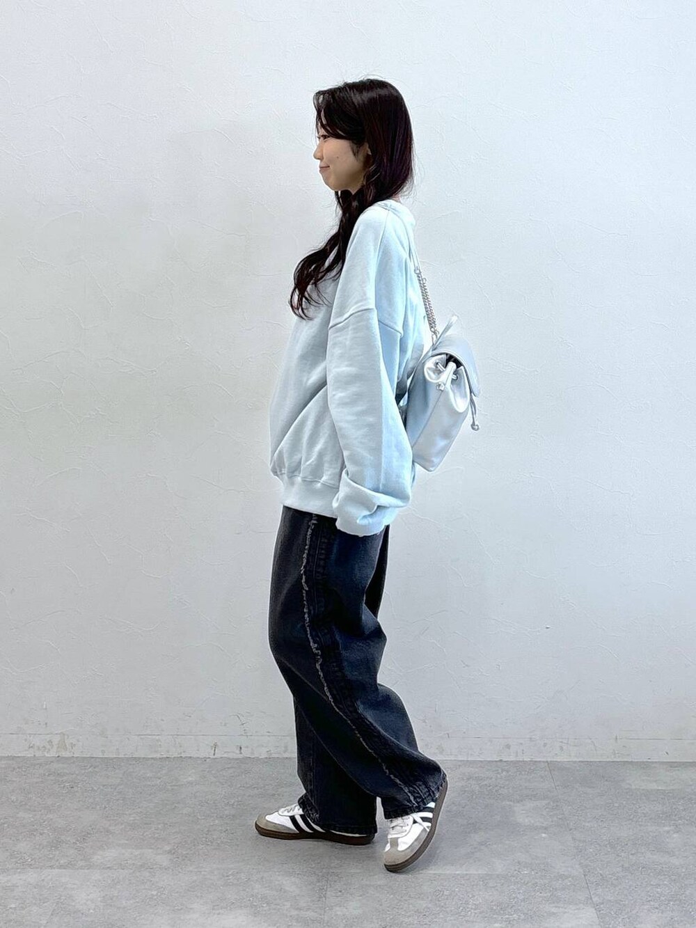 グレー系のバックパック/リュック、ブラック系のデニムパンツ、ブルー系のスウェットを着用したレディースの冬コーディネートの3枚目の写真