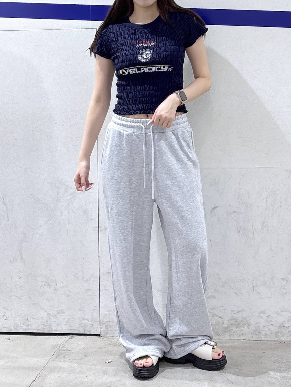 ホワイト系のサンダル、ブルー系のTシャツ/カットソー、グレー系のスウェットパンツを着用したレディースの夏コーディネートの2枚目の写真