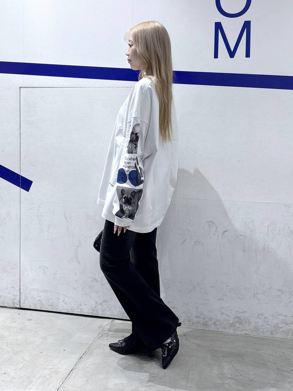 ブラック系のハンドバッグ、ブラック系のデニムパンツ、ブラック系のパンプスを着用したレディースの冬コーディネートの3枚目の写真