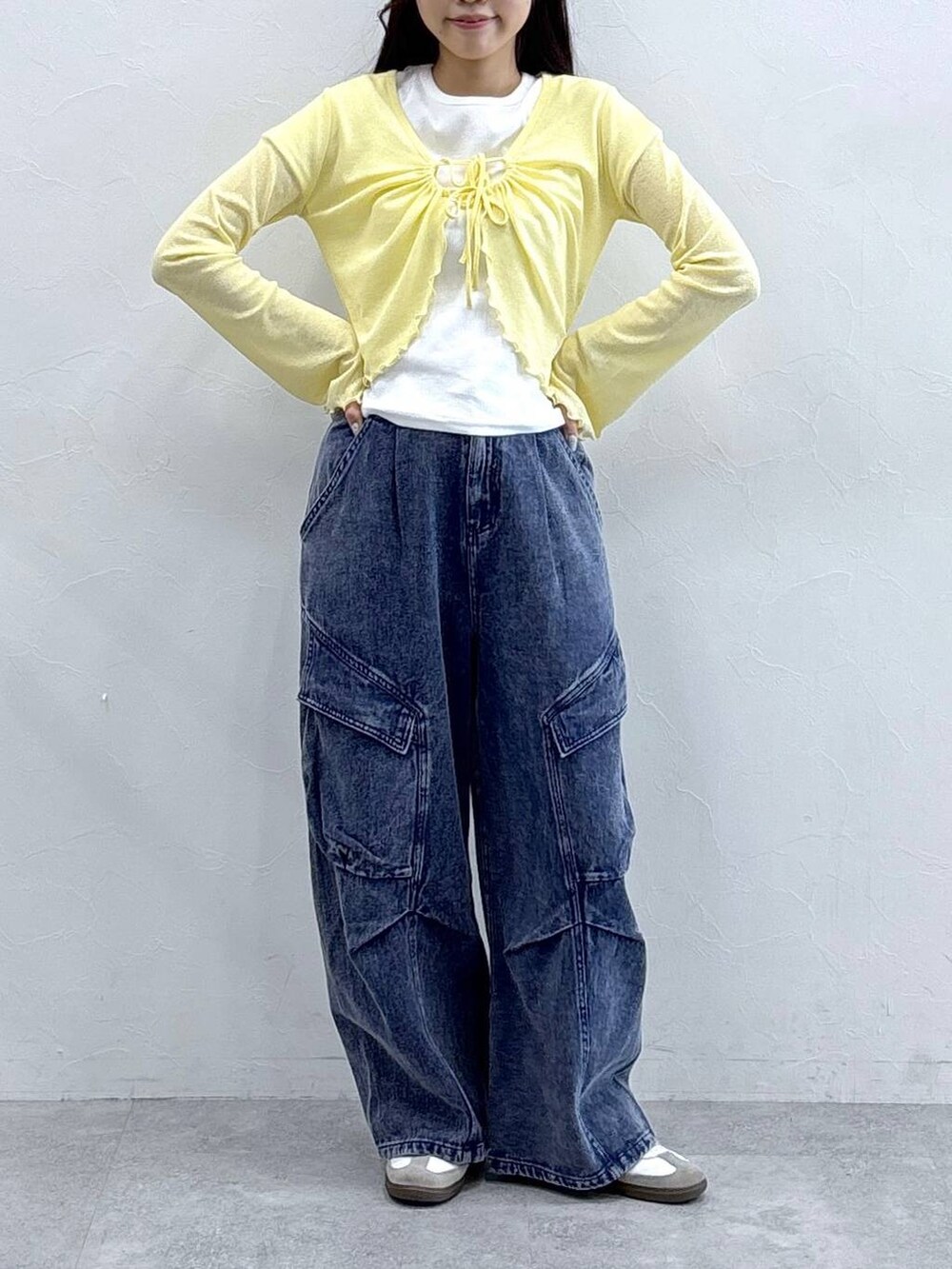 パープル系のカーゴパンツ、イエロー系のカーディガン/ボレロ、ベージュ系のTシャツ/カットソーを着用したレディースの春コーディネートの2枚目の写真