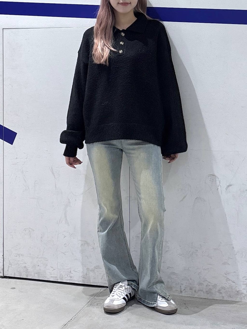 ブルー系のデニムパンツ、ブラック系のニット/セーター、ブラック系のショルダーバッグを着用したレディースの秋コーディネートの3枚目の写真