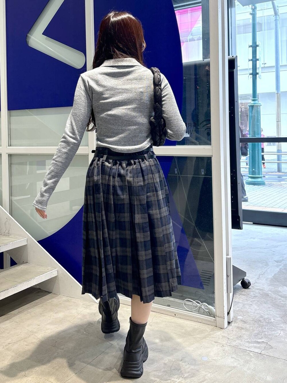 ブラック系のショルダーバッグ、グレー系のカーディガン/ボレロ、グレー系のスカートを着用したレディースの秋コーディネートの4枚目の写真