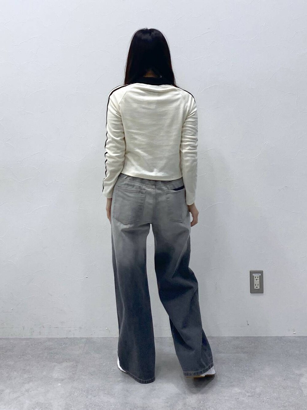 ブラック系のデニムパンツ、ベージュ系のTシャツ/カットソーを着用したレディースの春コーディネートの4枚目の写真