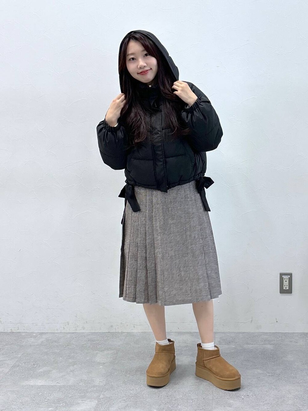ブラック系のダウンジャケット/コート、ブラウン系のスカートを着用したレディースの秋コーディネートの3枚目の写真