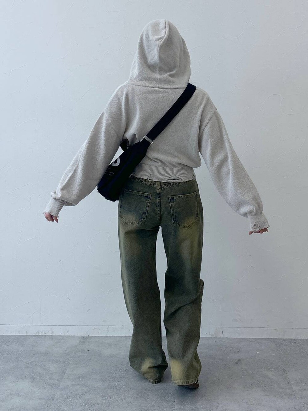 ブルー系のデニムパンツ、ブラック系のトートバッグを着用したレディースの春コーディネートの4枚目の写真