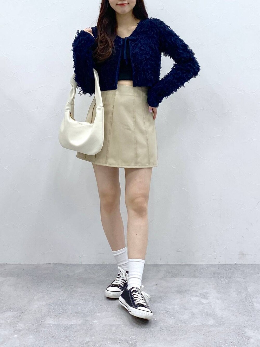 ベージュ系のスカート、ブルー系のカーディガン/ボレロを着用したレディースの春コーディネートの2枚目の写真