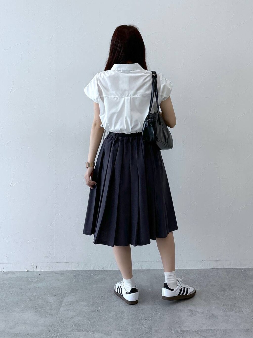 ブラック系のハンドバッグ、グレー系のスカート、ホワイト系のシャツ/ブラウスを着用したレディースの春コーディネートの4枚目の写真