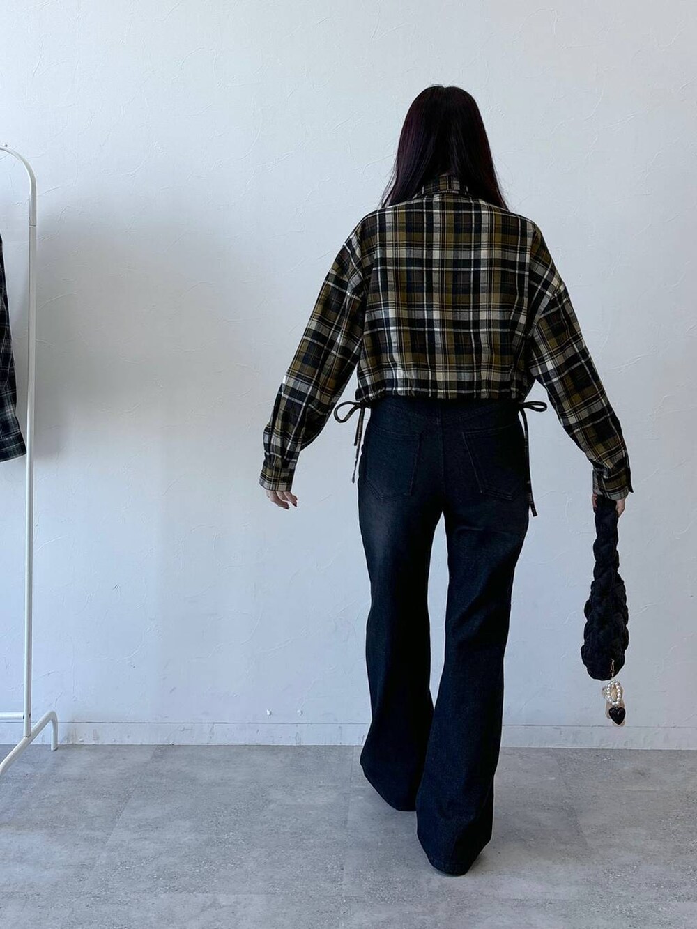 ブラック系のショルダーバッグ、ブラック系のデニムパンツ、イエロー系のシャツ/ブラウスを着用したレディースの冬コーディネートの4枚目の写真