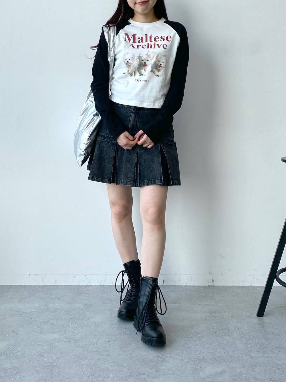 グレー系のトートバッグ、ホワイト系のTシャツ/カットソー、ブラック系のデニムスカートを着用したレディースの春コーディネートの2枚目の写真