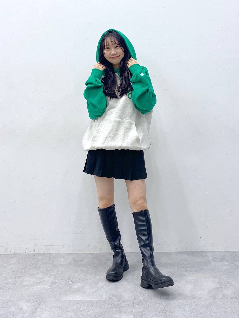 ブラック系のスカート、グリーン系のパーカーを着用したレディースの冬コーディネートの2枚目の写真