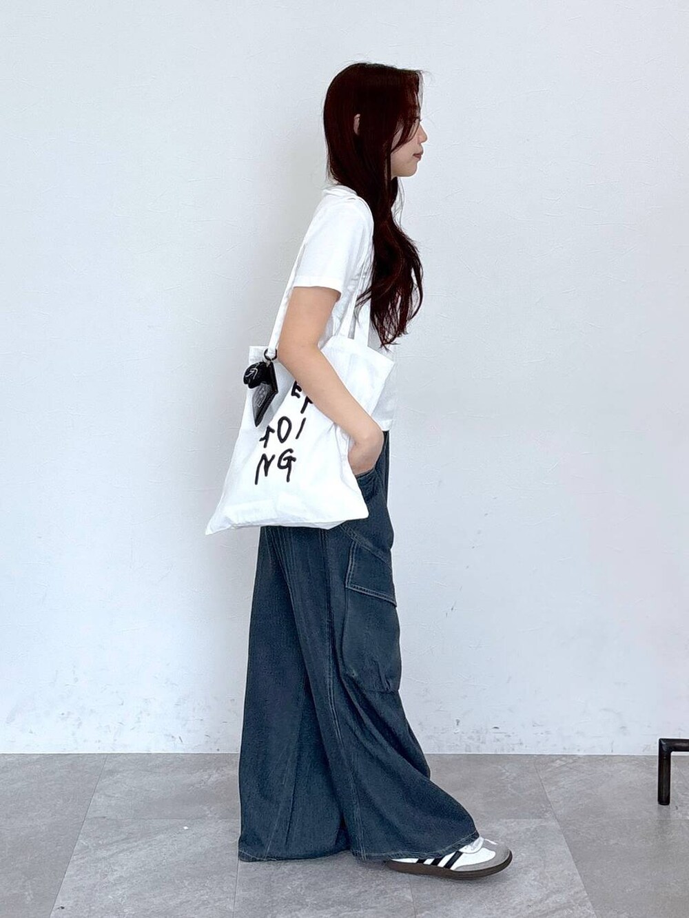 ブルー系のカーゴパンツ、その他のトートバッグ、ホワイト系のTシャツ/カットソーを着用したレディースの春コーディネートの6枚目の写真