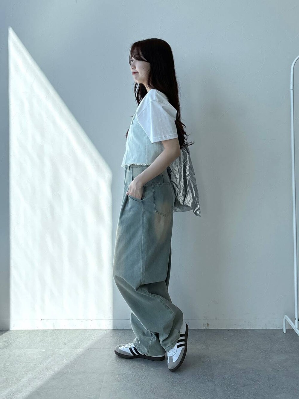 ブルー系のデニムパンツ、ホワイト系のTシャツ/カットソー、ブルー系のベストを着用したレディースの春コーディネートの3枚目の写真
