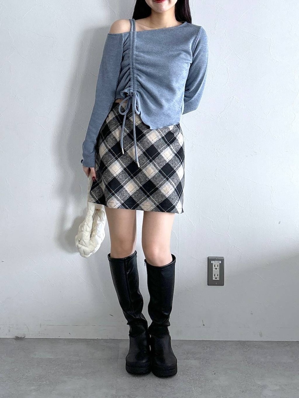 ホワイト系のショルダーバッグ、ブラック系のスカート、ブルー系のTシャツ/カットソーを着用したレディースの冬コーディネートの2枚目の写真