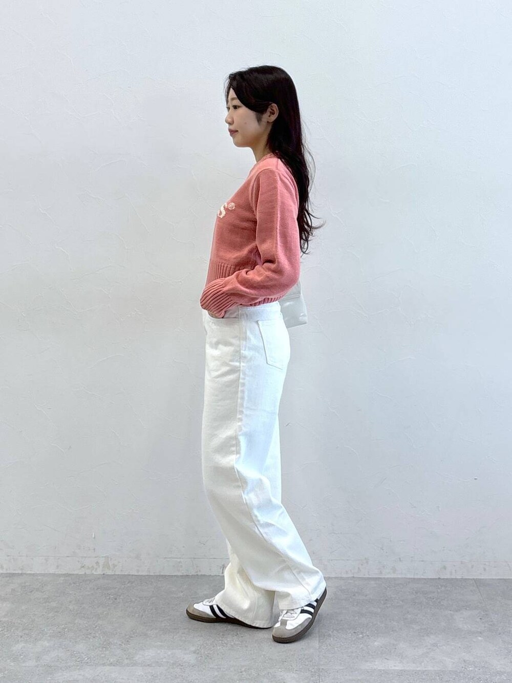 ホワイト系のハンドバッグ、ピンク系のニット/セーター、ベージュ系のその他パンツを着用したレディースの冬コーディネートの3枚目の写真