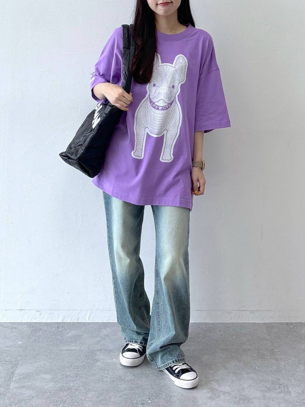 ブルー系のデニムパンツ、ブラック系のボストンバッグ、パープル系のTシャツ/カットソーを着用したレディースの夏コーディネートの2枚目の写真