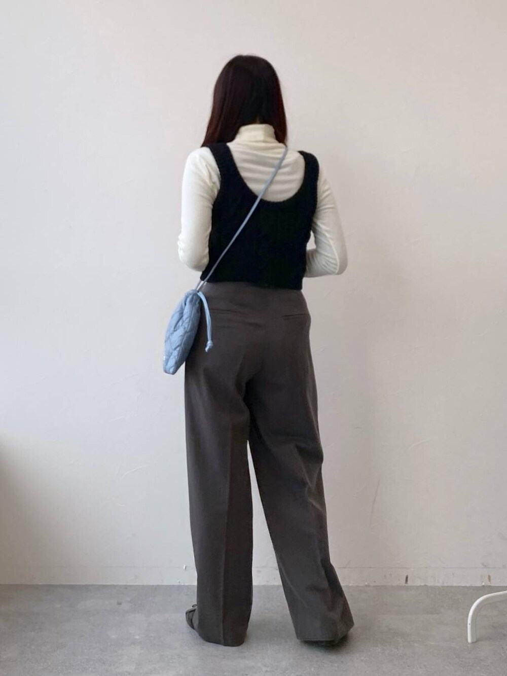 ブラック系のバレエシューズ、ブルー系のショルダーバッグ、グレー系のスラックスを着用したレディースの冬コーディネートの4枚目の写真