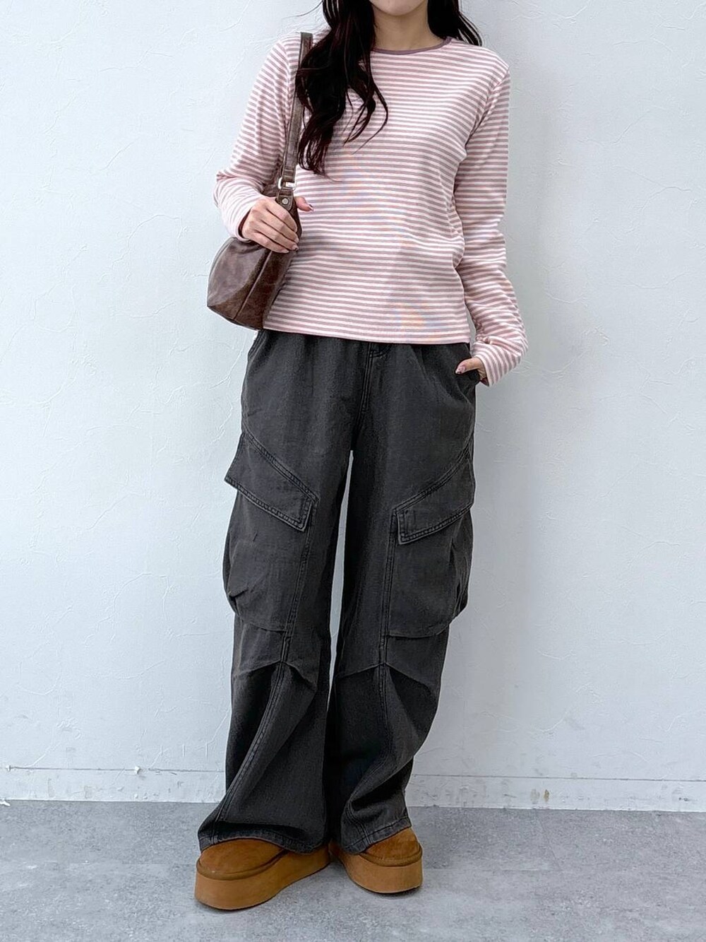 ブラウン系のハンドバッグを着用したレディースの春コーディネートの2枚目の写真