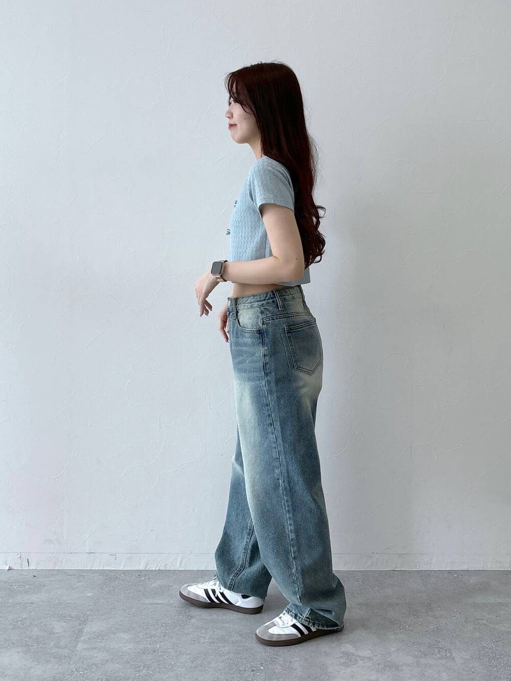 ブルー系のデニムパンツ、ベージュ系のチューブトップ、ブルー系のTシャツ/カットソーを着用したレディースの春コーディネートの3枚目の写真