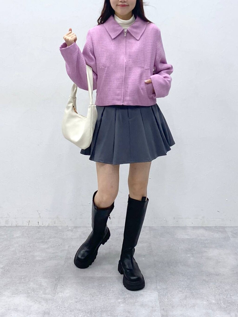 ブラック系のブーツ、ベージュ系のTシャツ/カットソー、グレー系のスカートを着用したレディースの冬コーディネートの2枚目の写真