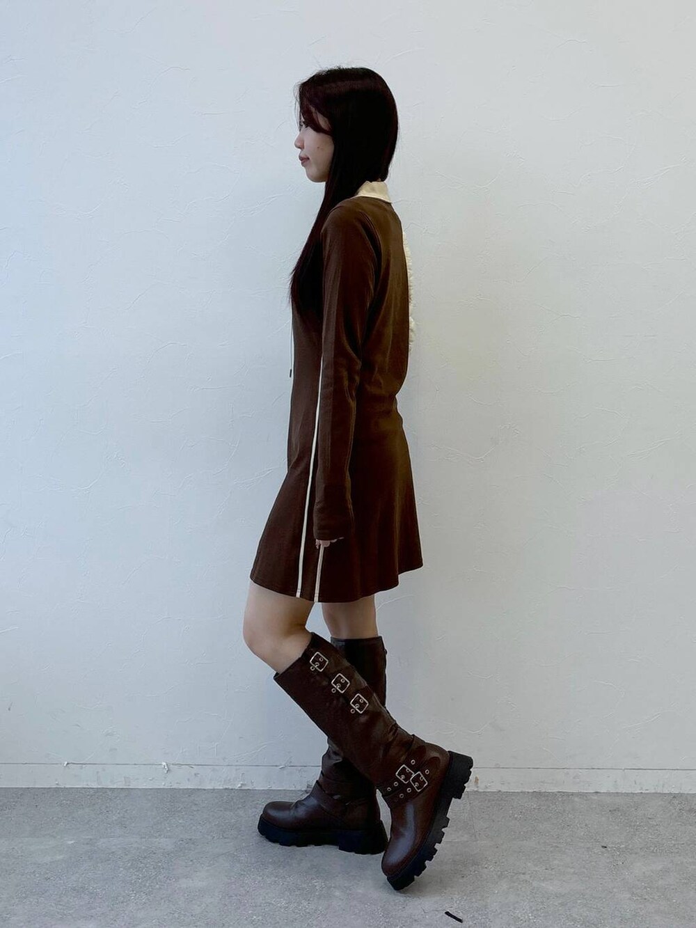 ホワイト系のショルダーバッグ、ブラウン系のブーツ、ブラウン系のワンピースを着用したレディースの冬コーディネートの3枚目の写真