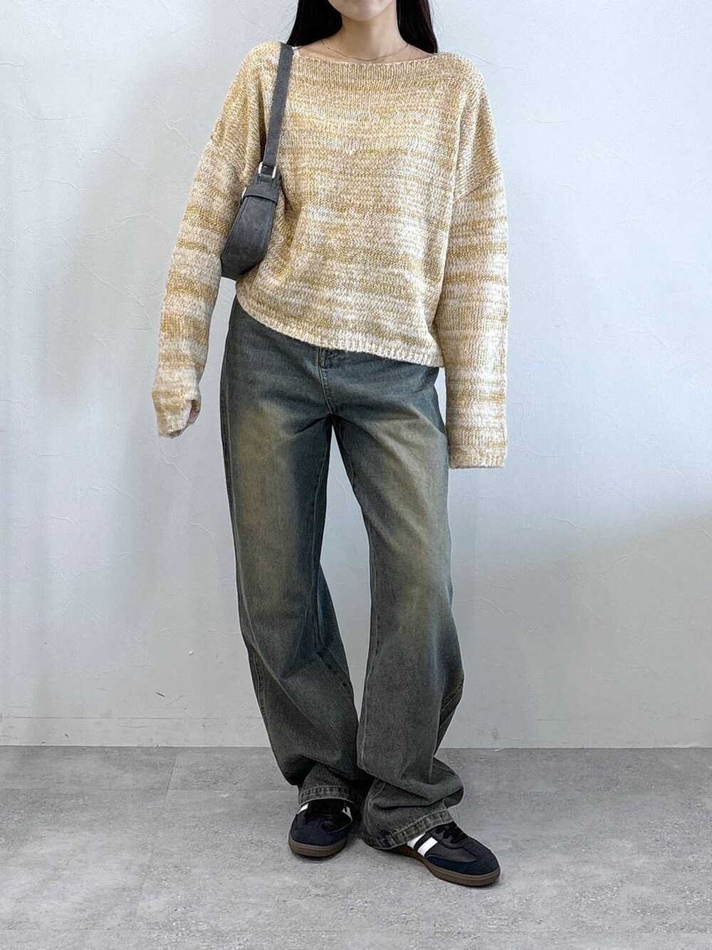 ブラック系のトートバッグ、ブルー系のデニムパンツ、ベージュ系のニット/セーターを着用したレディースの秋コーディネートの2枚目の写真