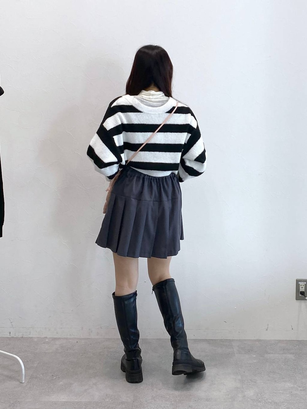 ピンク系のショルダーバッグ、ベージュ系のTシャツ/カットソー、グレー系のスカートを着用したレディースの冬コーディネートの4枚目の写真