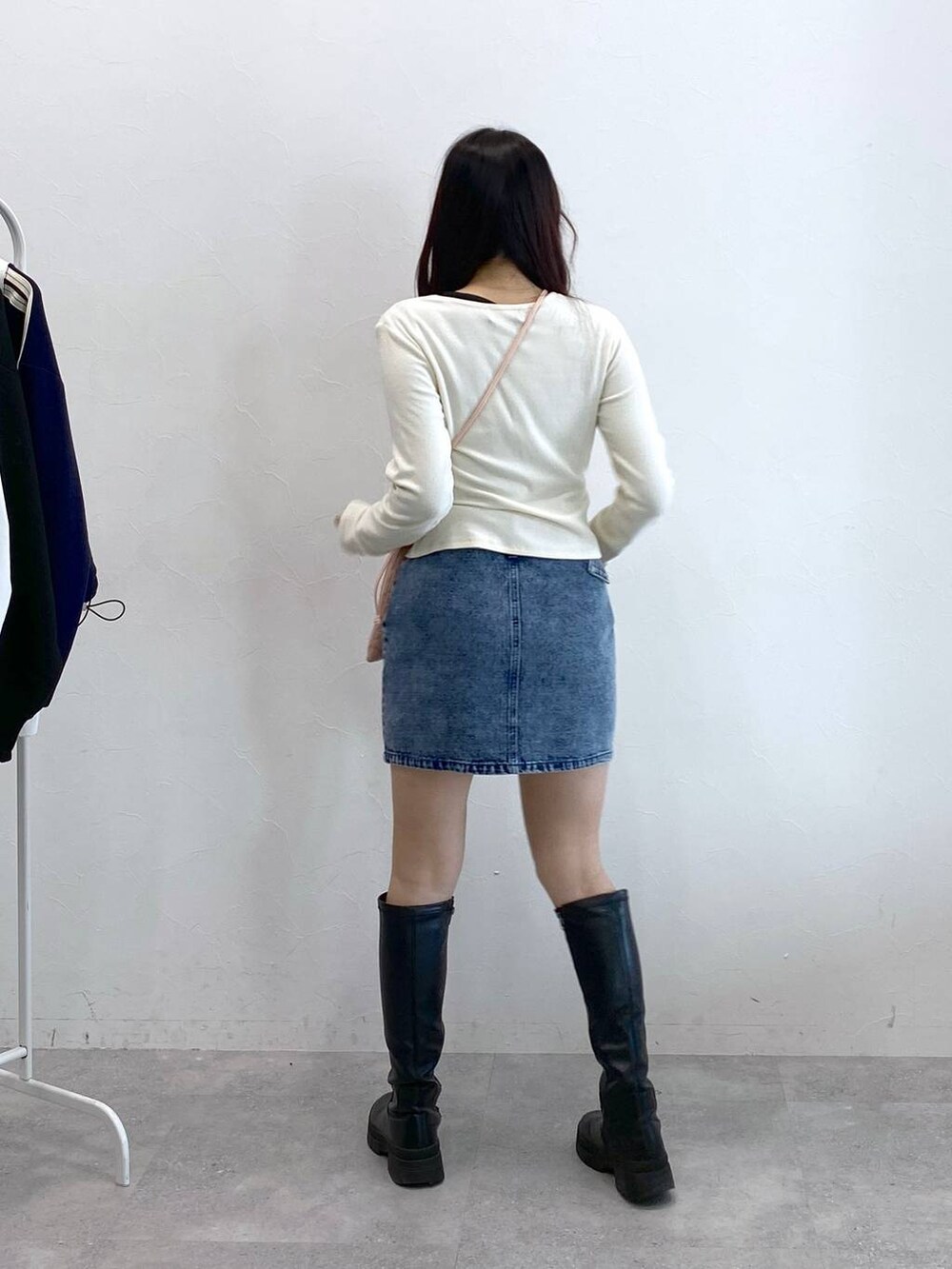 ブルー系のデニムスカート、ピンク系のショルダーバッグ、ベージュ系のTシャツ/カットソーを着用したレディースの冬コーディネートの5枚目の写真