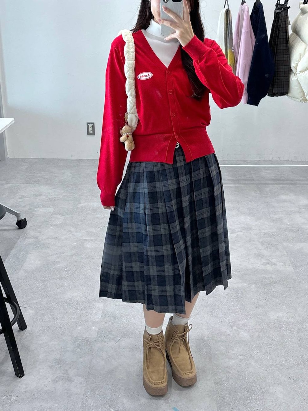 ホワイト系のショルダーバッグ、ホワイト系のニット/セーター、ベージュ系のブーツを着用したレディースの秋コーディネートの5枚目の写真