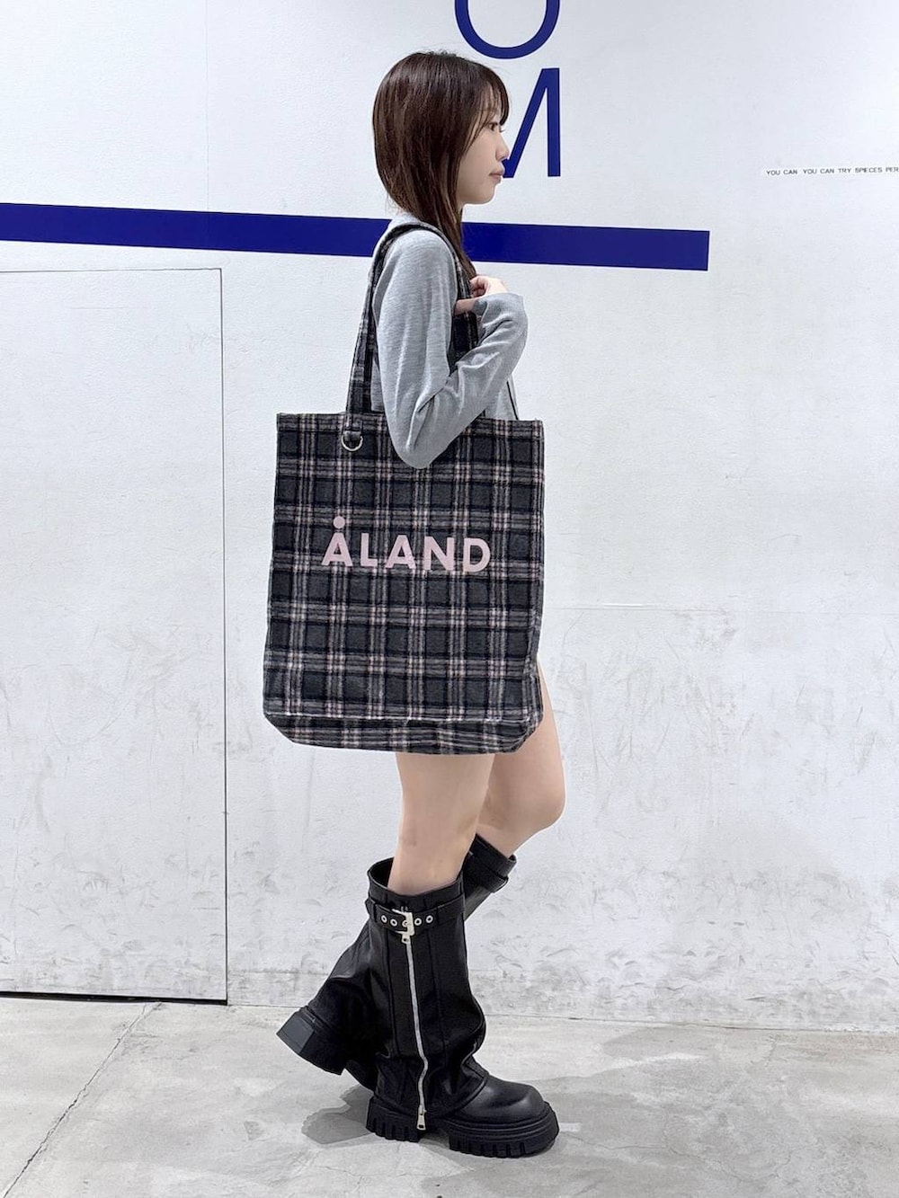 グレー系のカーディガン/ボレロ、グレー系のトートバッグ、ブラック系のブーツを着用したレディースの秋コーディネートの3枚目の写真