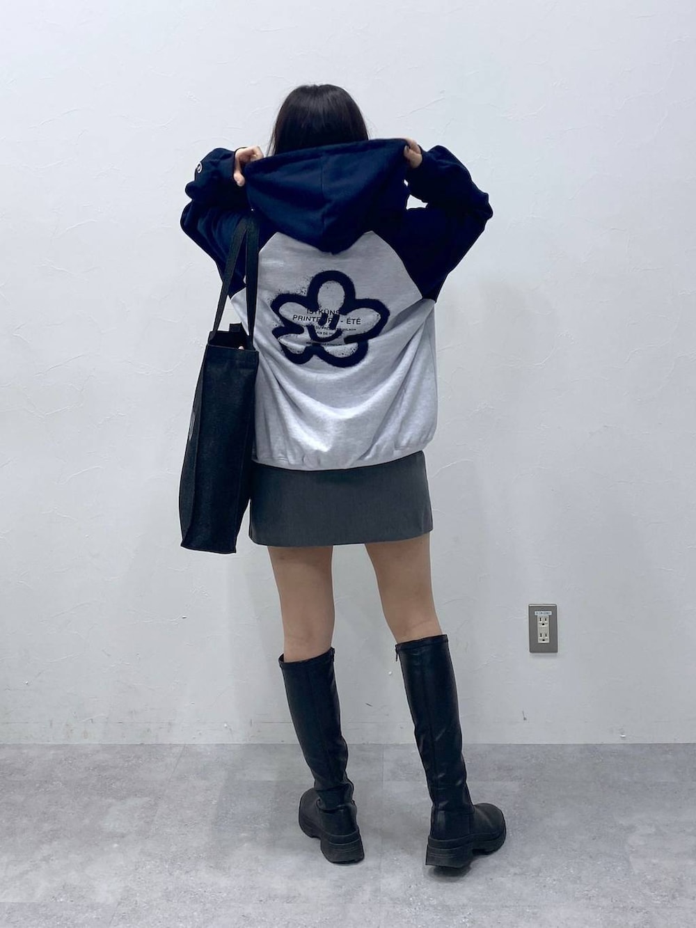 グレー系のスカート、ブルー系のトートバッグ、ブルー系のパーカーを着用したレディースの冬コーディネートの4枚目の写真