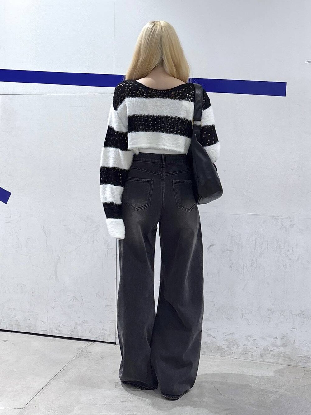 ブラック系のトートバッグ、ブラック系のデニムパンツを着用したレディースの秋コーディネートの4枚目の写真