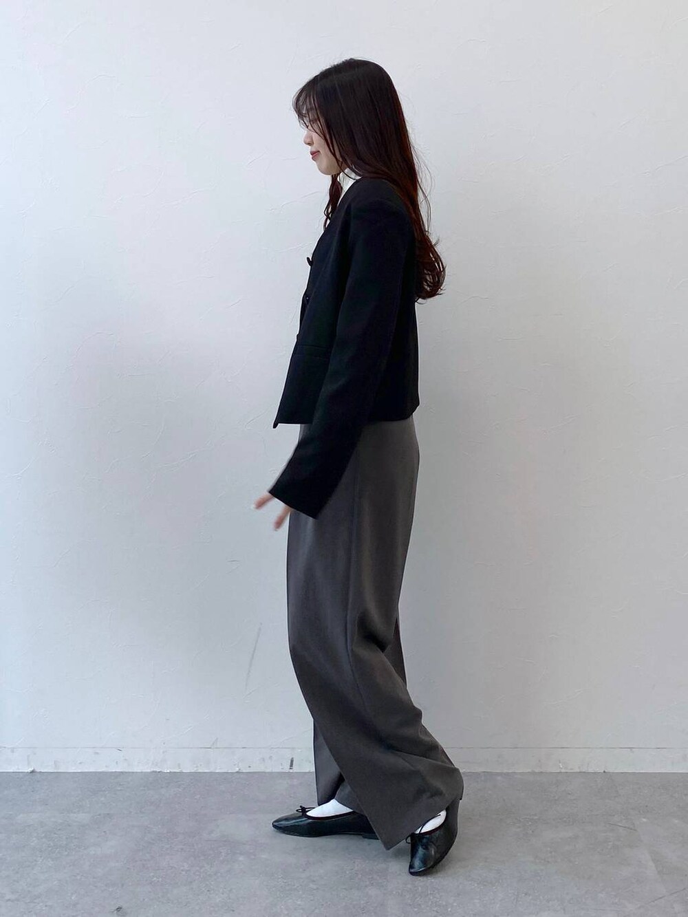 ブラック系のバレエシューズ、グレー系のスラックス、ブラック系のノーカラージャケットを着用したレディースの冬コーディネートの5枚目の写真