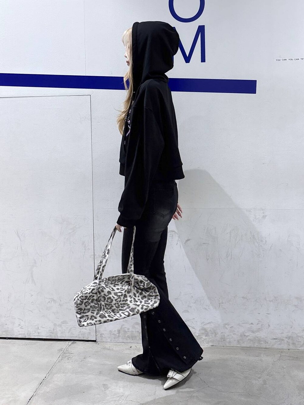 ホワイト系のパンプス、ブラック系のデニムパンツ、ホワイト系のショルダーバッグを着用したレディースの冬コーディネートの3枚目の写真