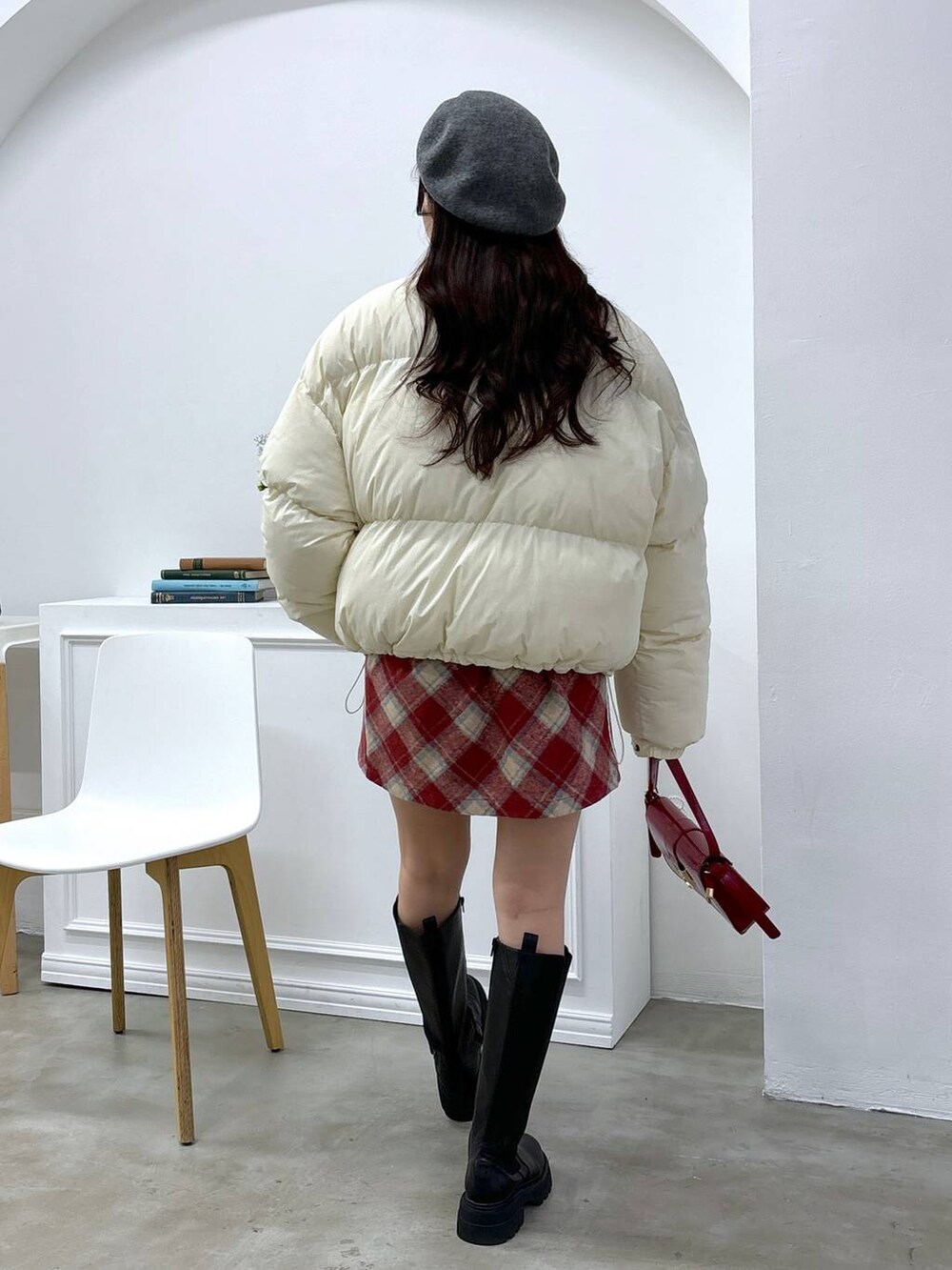 グレー系のカーディガン/ボレロ、ベージュ系のダウンジャケット/コート、レッド系のスカートを着用したレディースの秋コーディネートの4枚目の写真