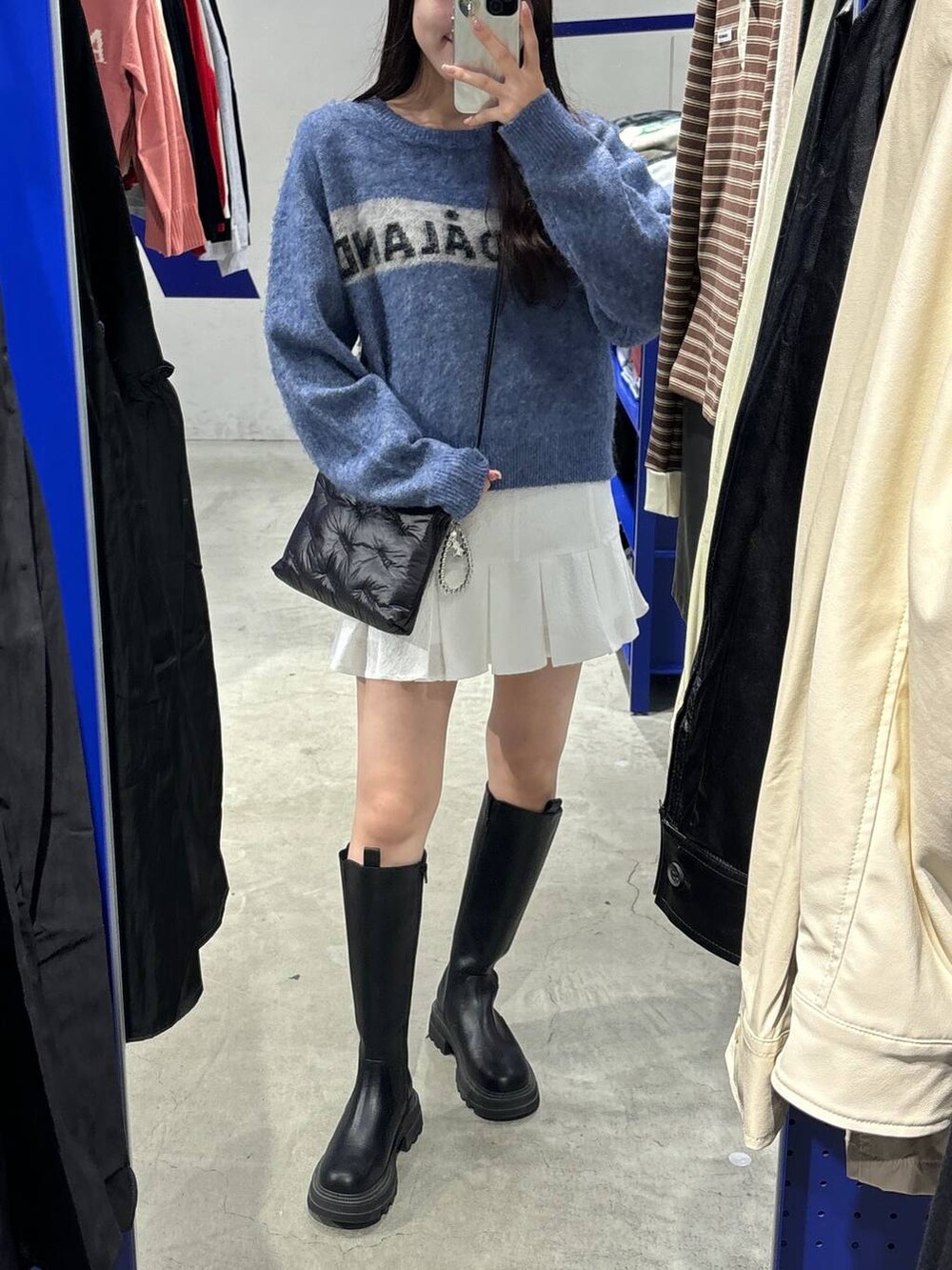 ホワイト系のスカート、ブラック系のブーツ、ブラック系のショルダーバッグを着用したレディースの秋コーディネートの5枚目の写真