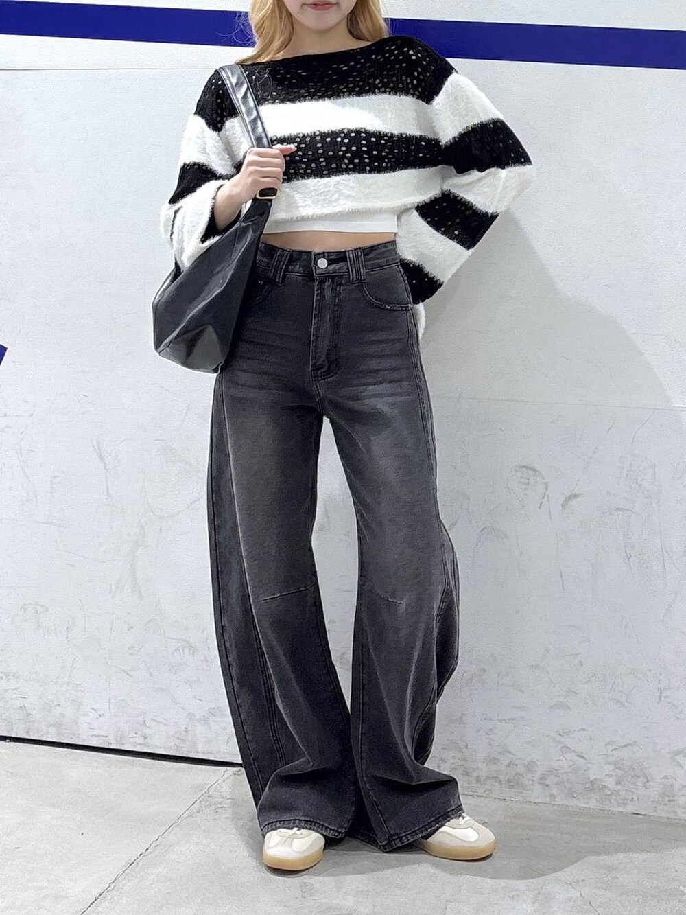 ブラック系のトートバッグ、ブラック系のデニムパンツを着用したレディースの秋コーディネートの2枚目の写真