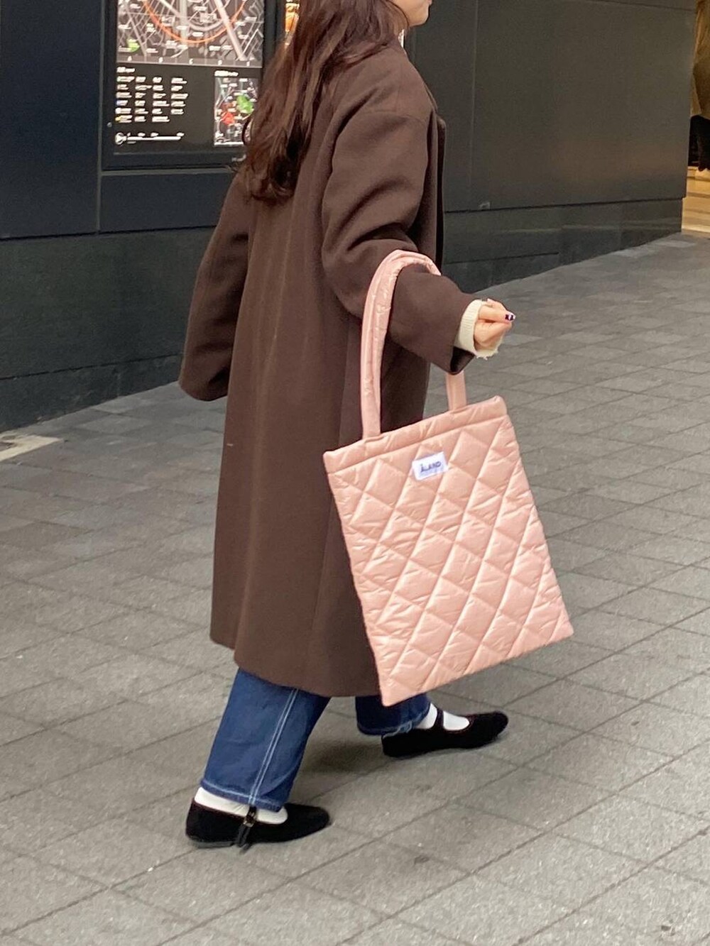 ブラック系のパンプス、ピンク系のトートバッグ、オレンジ系のニット/セーターを着用したレディースの冬コーディネートの3枚目の写真