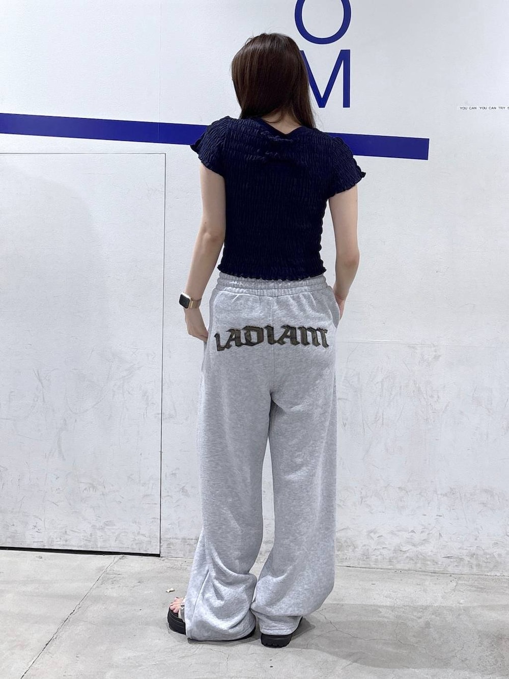 ホワイト系のサンダル、ブルー系のTシャツ/カットソー、グレー系のスウェットパンツを着用したレディースの夏コーディネートの4枚目の写真