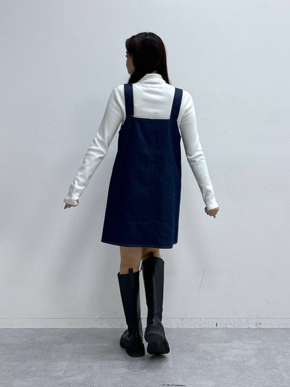 ホワイト系のニット/セーター、ブラック系のブーツを着用したレディースの冬コーディネートの4枚目の写真