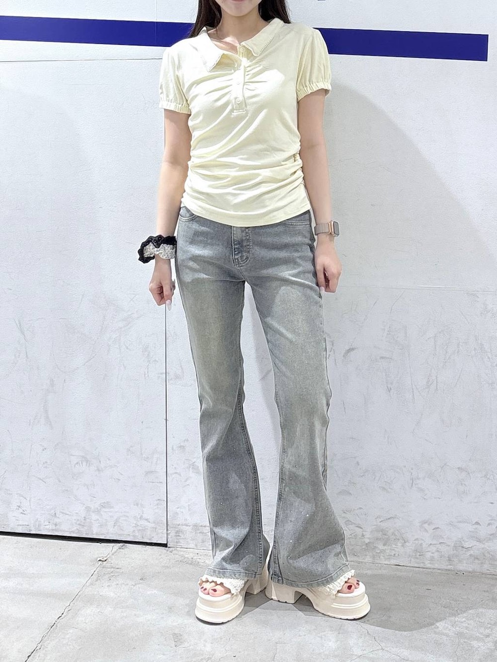 ホワイト系のサンダル、ベージュ系のTシャツ/カットソー、ブルー系のデニムパンツを着用したレディースの夏コーディネートの2枚目の写真